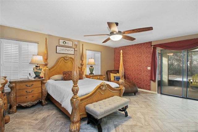 bedroom with access to outside, baseboards, ceiling fan, and brick wall