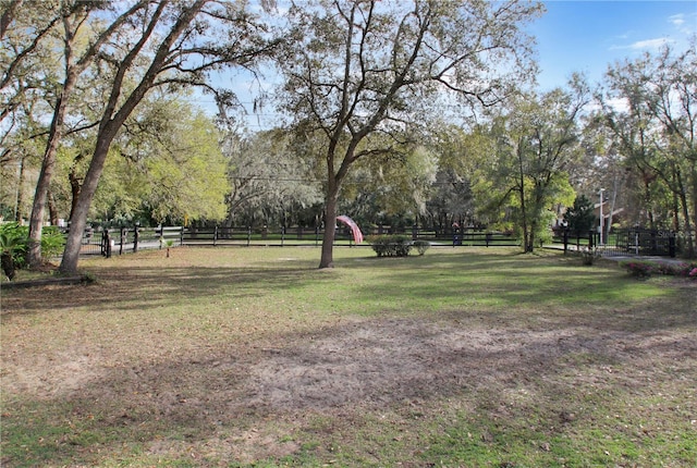 view of property's community featuring fence and a lawn