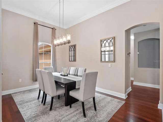 dining room featuring baseboards, wood finished floors, and ornamental molding