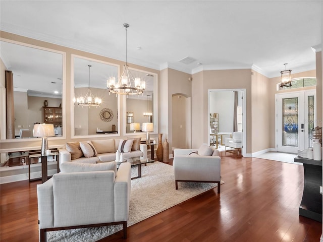 living area with a chandelier, baseboards, wood finished floors, and ornamental molding