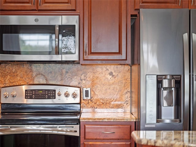 kitchen with brown cabinetry, backsplash, stainless steel appliances, and light stone countertops