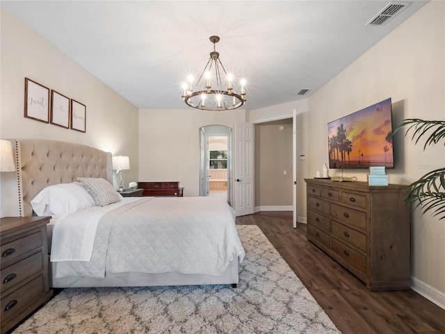 bedroom with arched walkways, visible vents, dark wood-type flooring, and baseboards