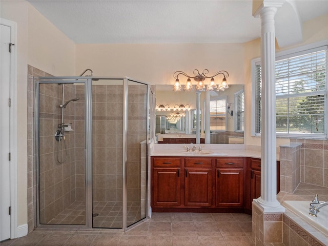 full bathroom featuring tile patterned floors, vanity, a shower stall, and ornate columns