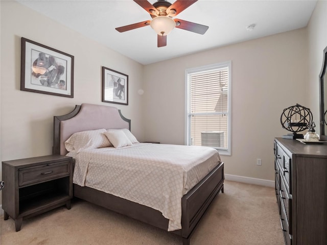 bedroom featuring baseboards, light colored carpet, and a ceiling fan