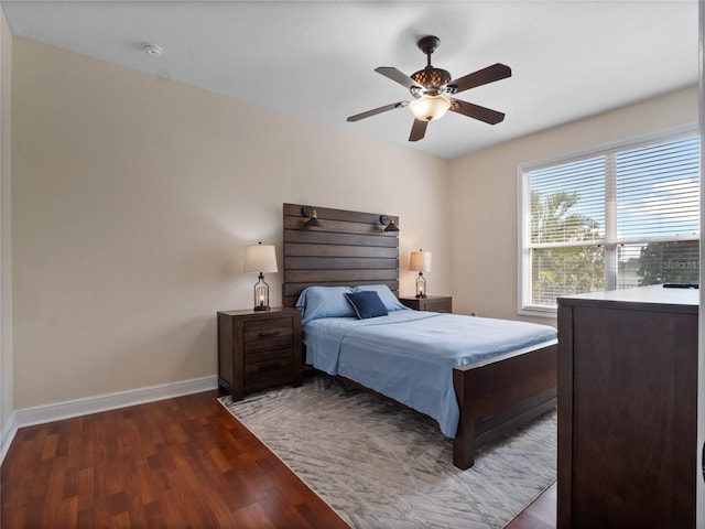 bedroom with baseboards, ceiling fan, and dark wood-style flooring