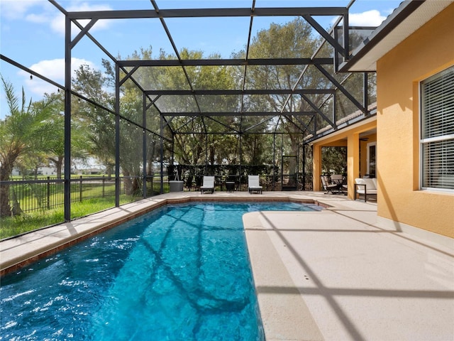 view of pool featuring glass enclosure, fence, a patio, and a fenced in pool