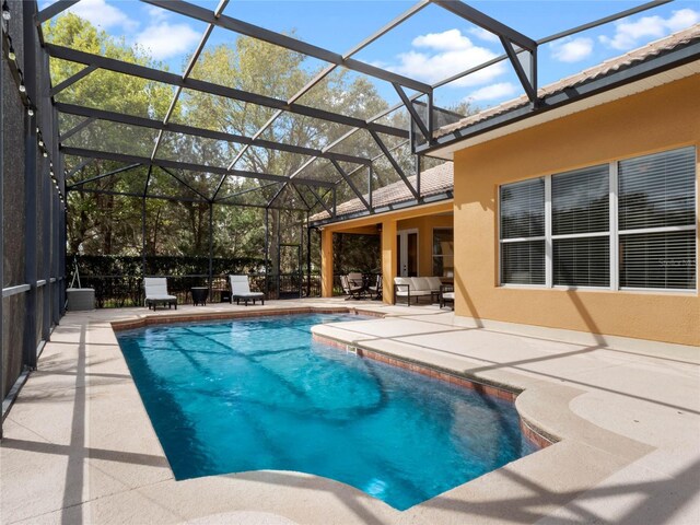 view of pool with a fenced in pool, glass enclosure, and a patio