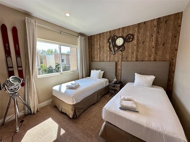 carpeted bedroom with baseboards and wooden walls