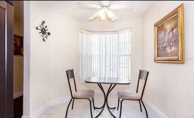 dining room with light tile patterned floors, ceiling fan, and baseboards