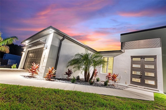 exterior space featuring an attached garage, concrete driveway, and stucco siding