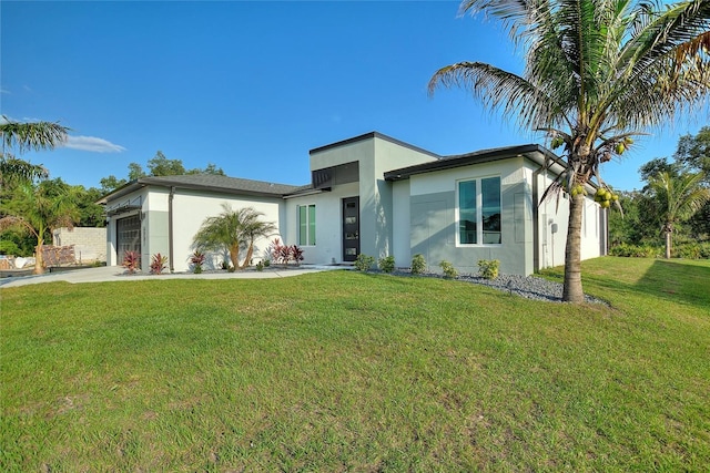 view of front of house featuring a garage, a front yard, concrete driveway, and stucco siding