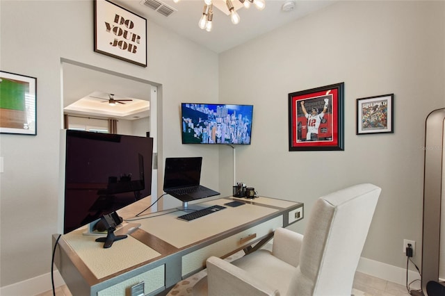 office area featuring a ceiling fan, a raised ceiling, visible vents, and baseboards