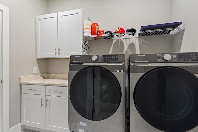 laundry room with separate washer and dryer and cabinet space