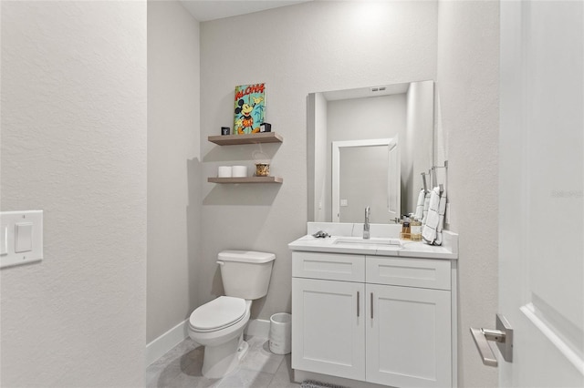 bathroom with toilet, baseboards, and vanity