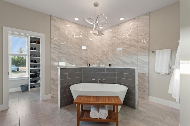 full bathroom featuring tile walls, recessed lighting, a freestanding bath, a spacious closet, and a walk in shower