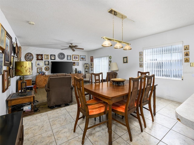 dining room featuring light tile patterned floors, ceiling fan, and a textured ceiling