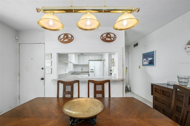 dining room with visible vents and a textured ceiling