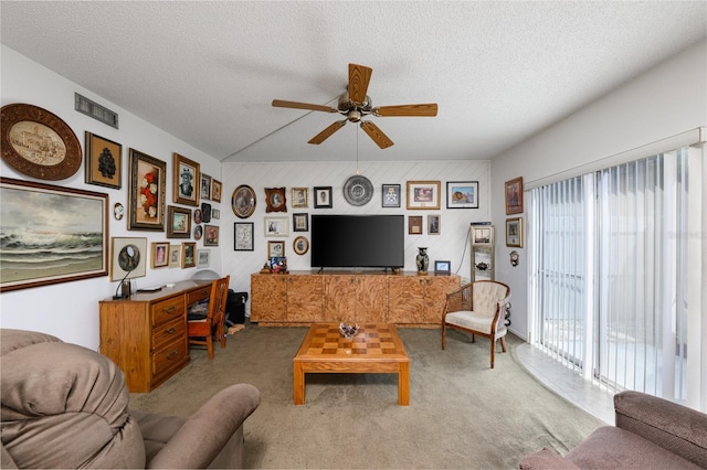 carpeted living room featuring a ceiling fan, visible vents, vaulted ceiling, and a textured ceiling