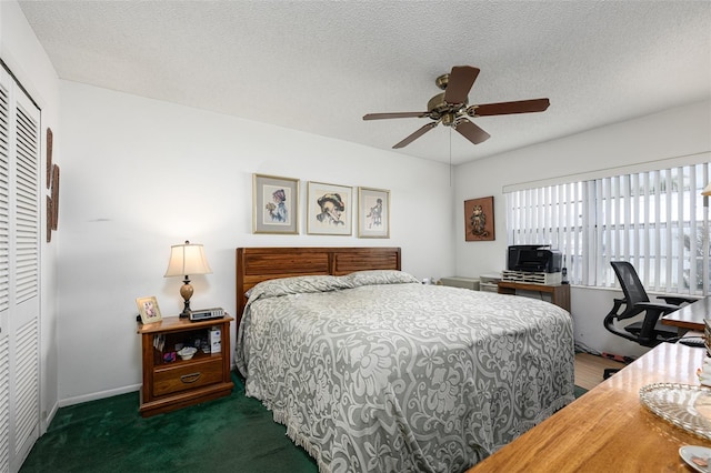 carpeted bedroom with a textured ceiling, a closet, a ceiling fan, and baseboards