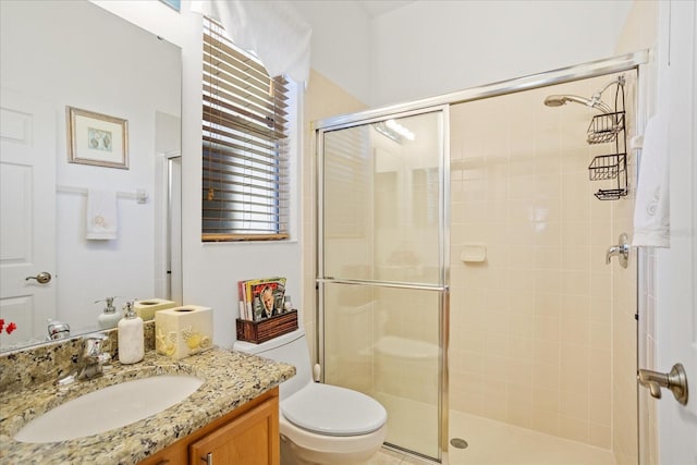 bathroom with vanity, a shower stall, and toilet