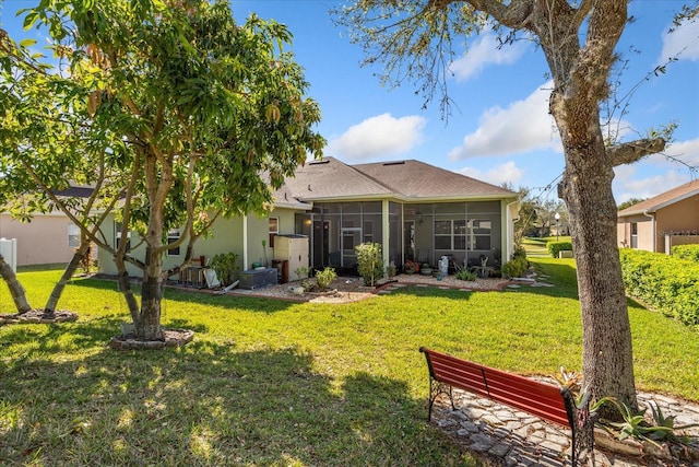 back of house featuring a lawn and a sunroom