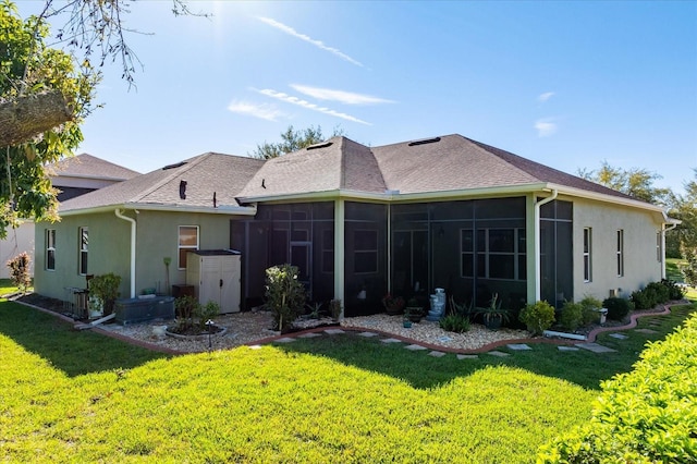 rear view of property featuring stucco siding, roof with shingles, a yard, and a sunroom