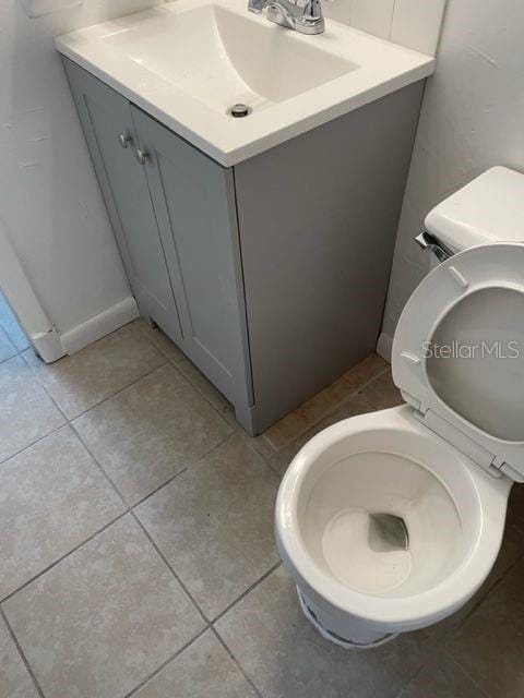 bathroom featuring tile patterned flooring, toilet, and vanity