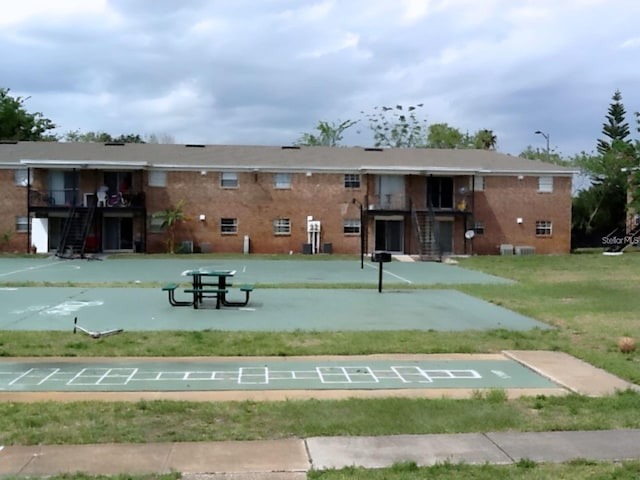 surrounding community featuring a lawn and shuffleboard