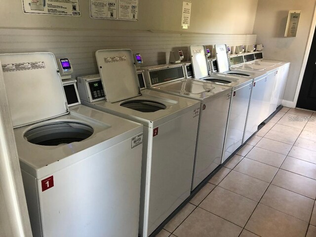 shared laundry area with light tile patterned floors and independent washer and dryer