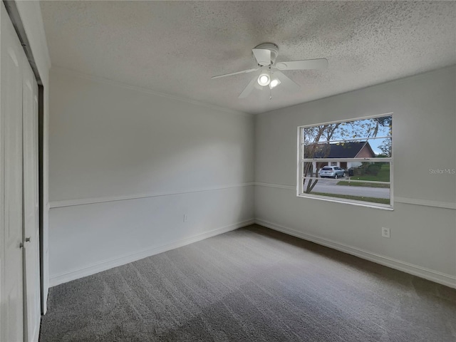 unfurnished bedroom with a textured ceiling, ceiling fan, baseboards, a closet, and carpet