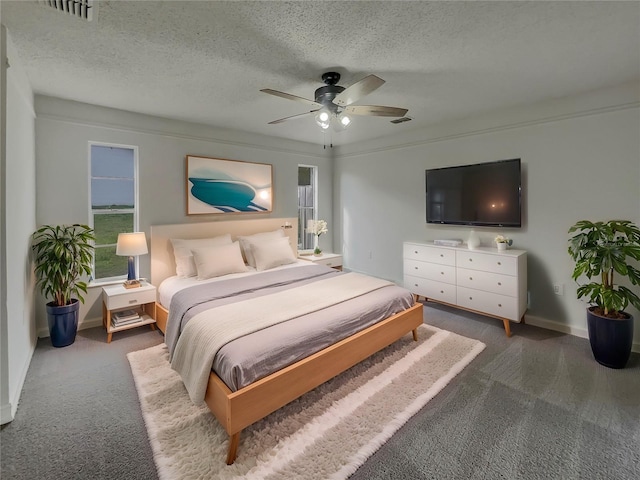 carpeted bedroom with visible vents, ceiling fan, a textured ceiling, and baseboards