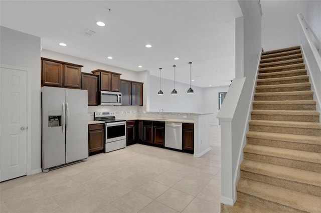 kitchen with dark brown cabinetry, appliances with stainless steel finishes, a peninsula, light countertops, and recessed lighting