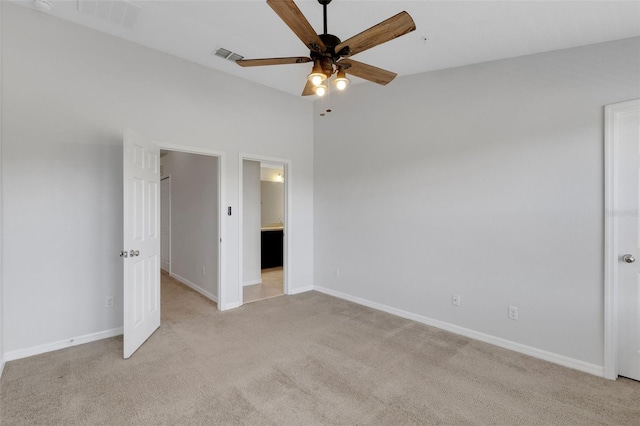 unfurnished bedroom featuring light carpet, ensuite bath, baseboards, and visible vents