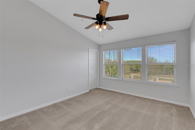 empty room with lofted ceiling, baseboards, a wealth of natural light, and light colored carpet