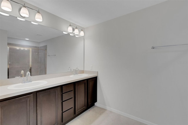 full bath featuring a stall shower, a sink, baseboards, and double vanity