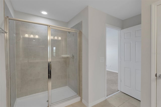 full bathroom featuring a shower stall, baseboards, and tile patterned floors