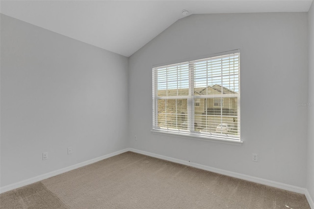 carpeted empty room with lofted ceiling and baseboards