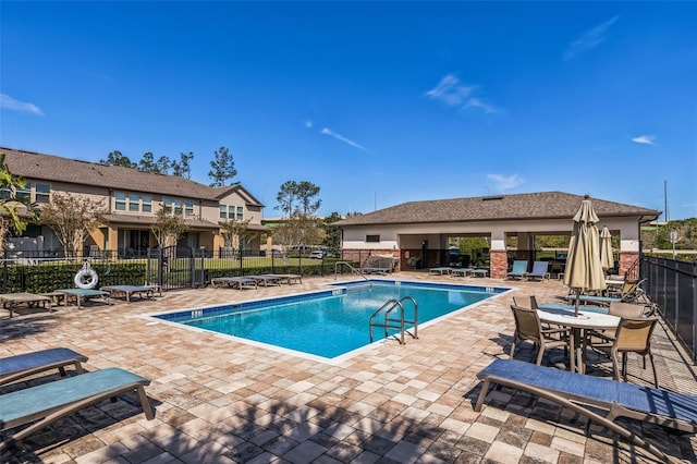 community pool featuring fence and a patio