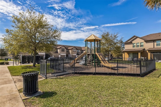 community play area with a residential view, a lawn, and fence