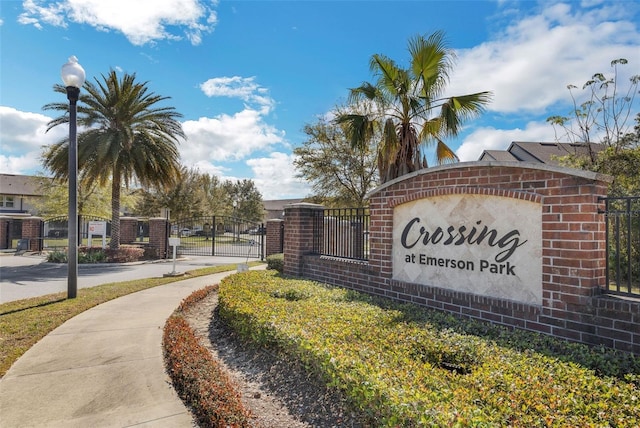 community sign featuring a gate and fence