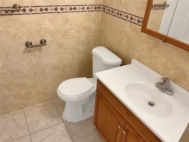 bathroom with tile patterned flooring, vanity, toilet, and tile walls