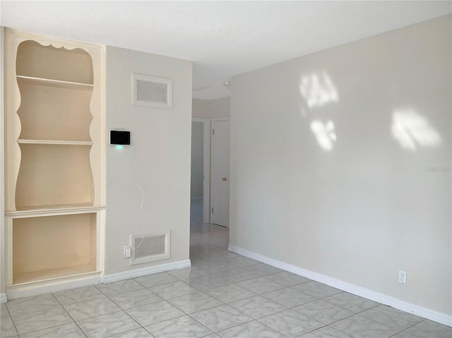 empty room with baseboards and visible vents