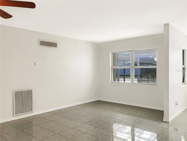 empty room with a ceiling fan, visible vents, and baseboards