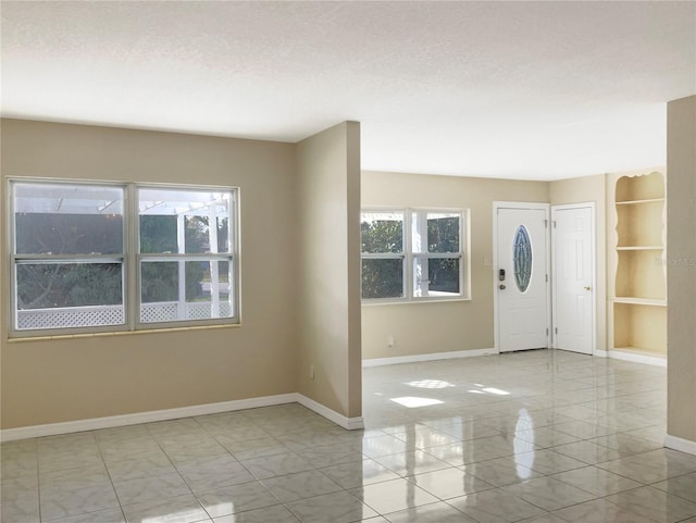 entryway featuring a textured ceiling and baseboards