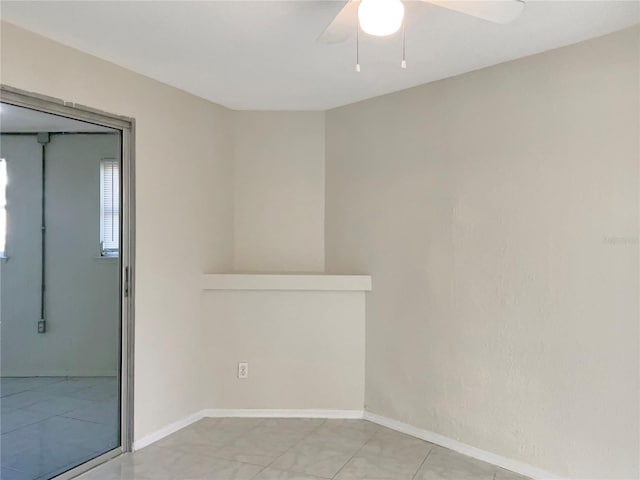 empty room featuring a ceiling fan and baseboards