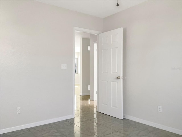 empty room featuring marble finish floor and baseboards