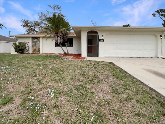 ranch-style house with driveway, a garage, a front lawn, and stucco siding