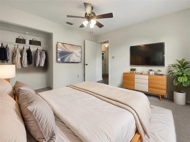 carpeted bedroom with a closet, visible vents, and ceiling fan