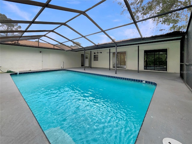 pool with a ceiling fan, glass enclosure, and a patio area