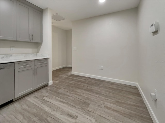 kitchen featuring dishwasher, light wood finished floors, and gray cabinetry